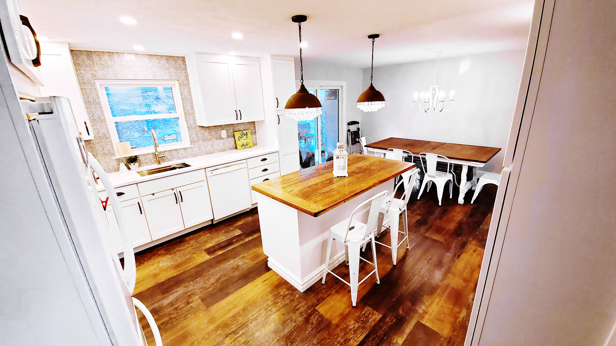 A bright kitchen with wood accents featuring an island and chandelier lighting