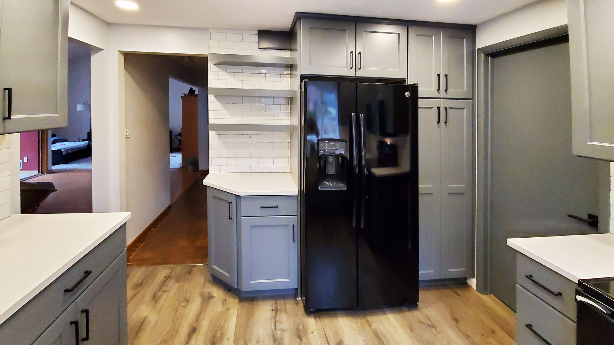 A newly remodeled kitchen with new cabinets, flooring, and shelving