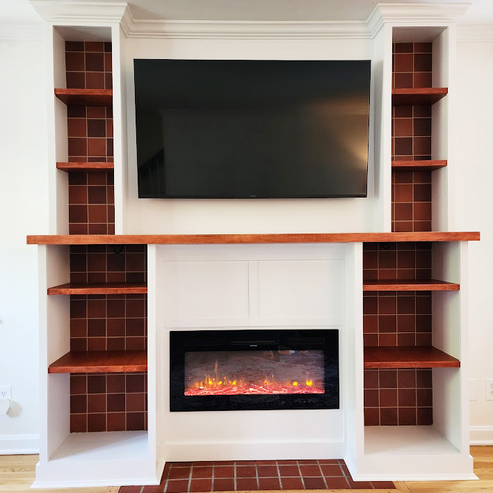 Complete Kitchen Overhaul-After Entertainment Center with electric fireplace and tile behind built-in shelves