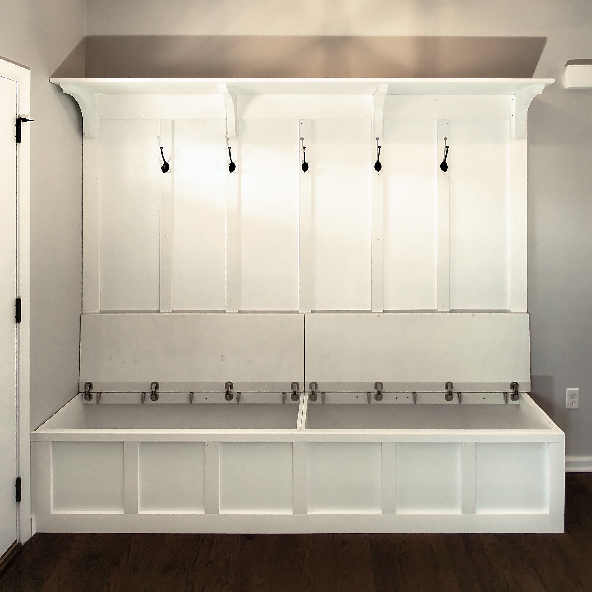 A custom-built hallway coat rack and bench with hidden storage